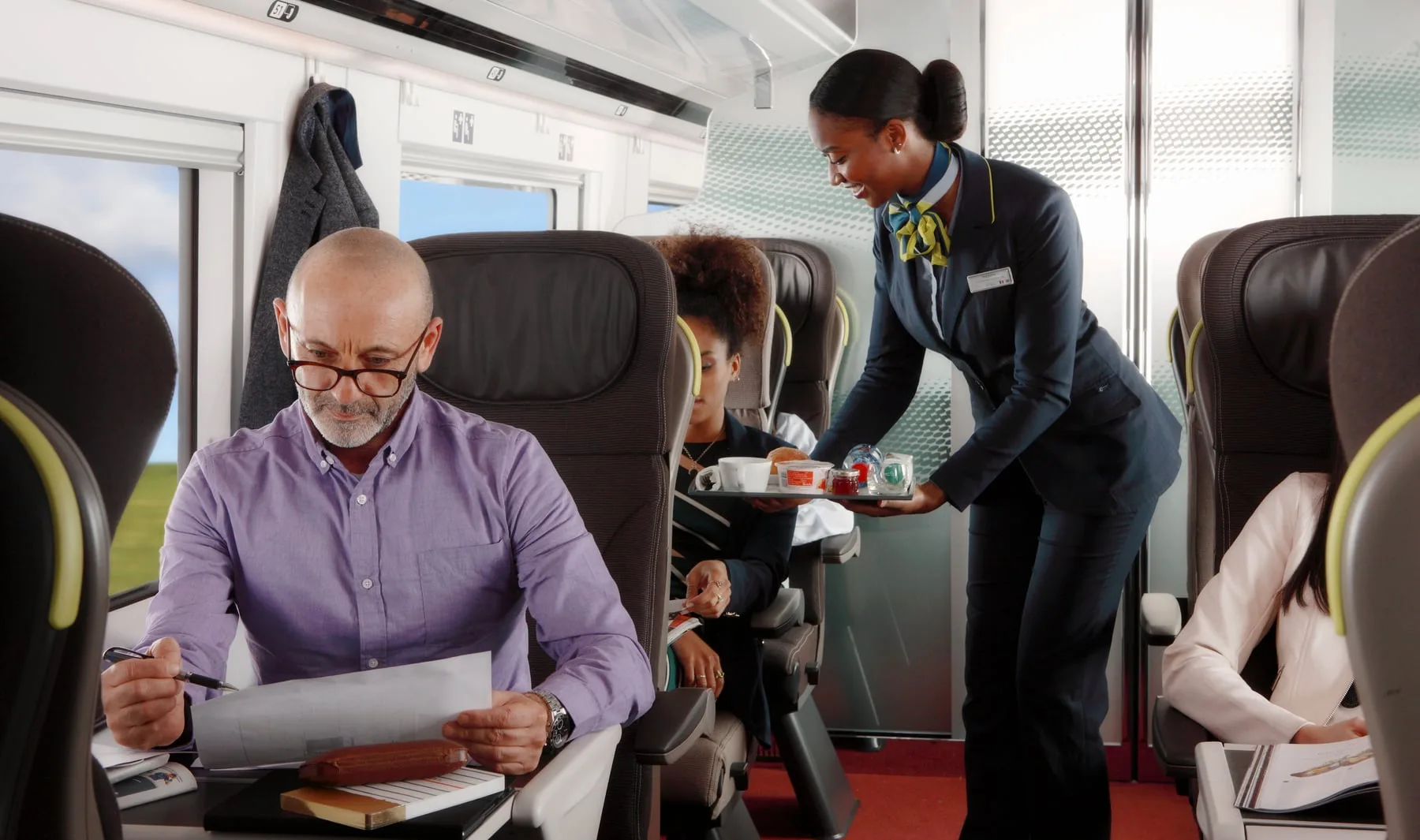 Eurostar commercial photography, steward serving refreshments through the carriage