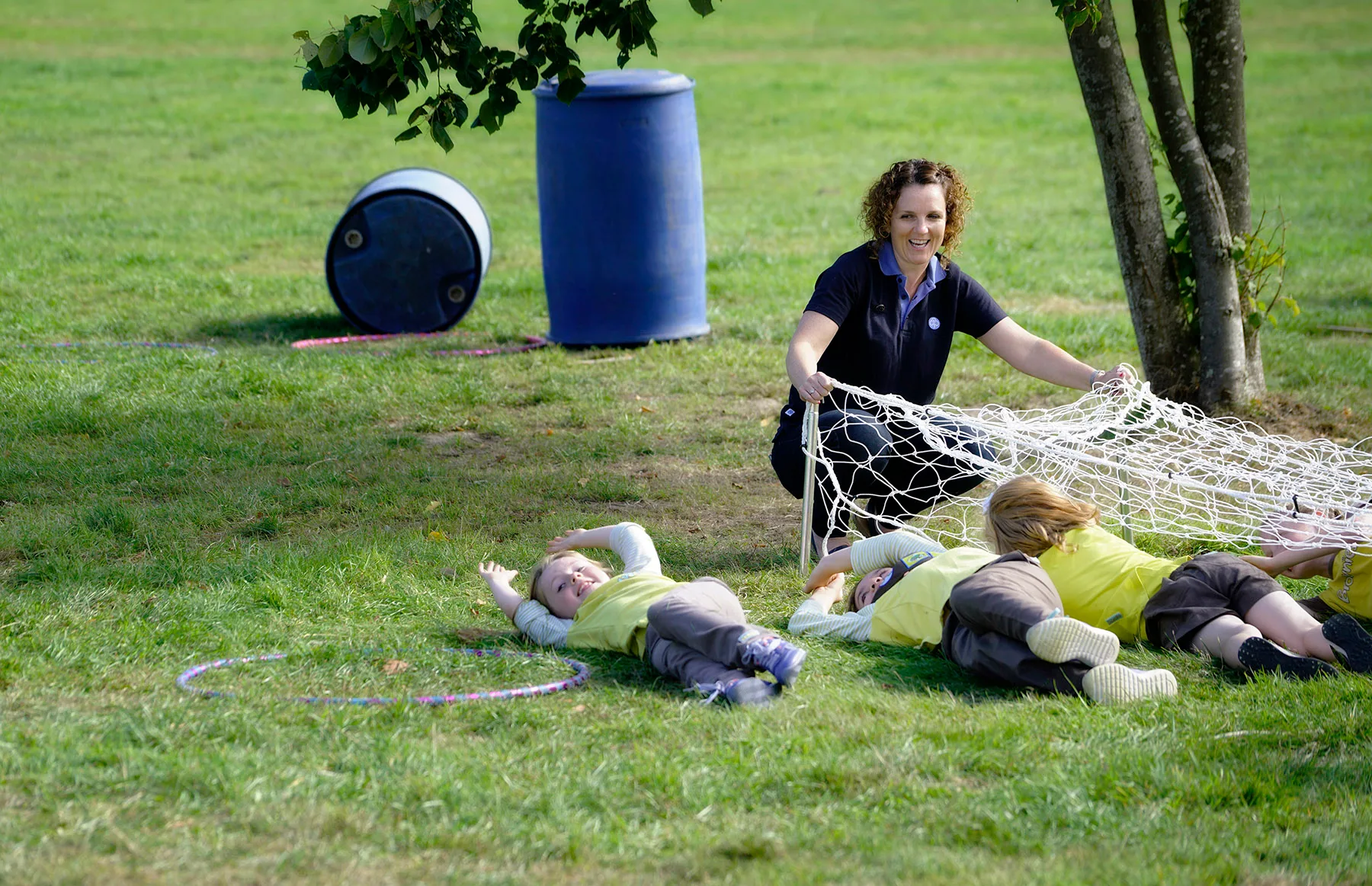 A Girlguiding leader and children playing with a net in a park, Inspire Girls