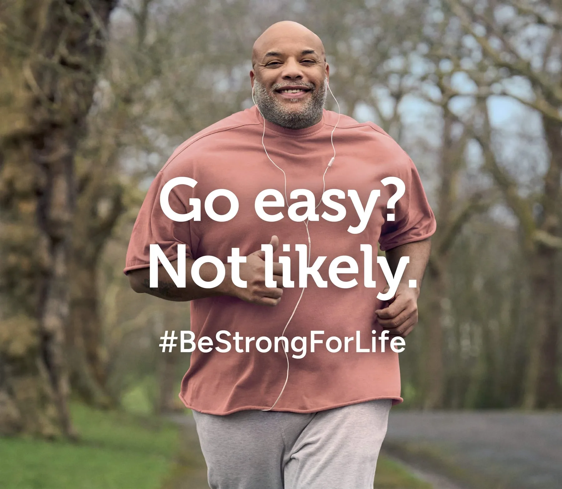 A man jogging on a tree-lined path, Holland & Barrett #BeStrongForLife