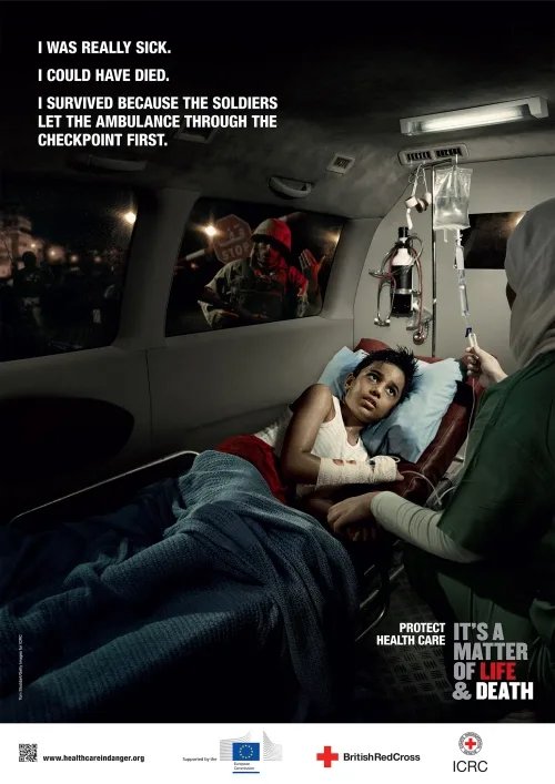 ICRC 'Health Care in Danger' poster — a sick child on an ambulance drip passing a checkpoint, 'It's a Matter of Life & Death'