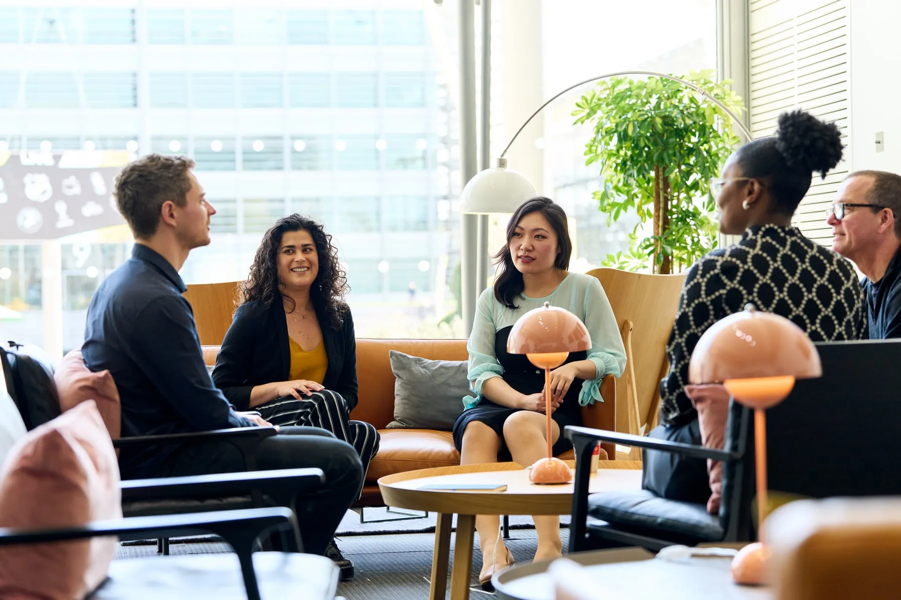 International SOS colleagues talking in a plant-filled office lounge in London