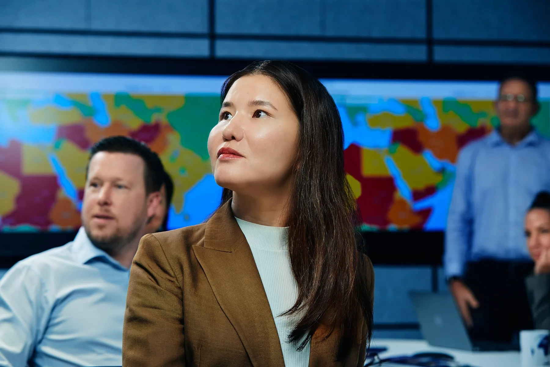 An International SOS specialist before a wall-mounted global risk map in a Dubai briefing room