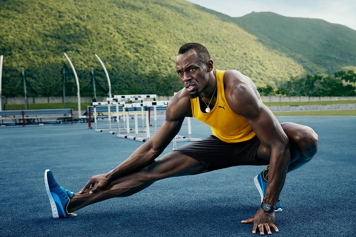 Usain Bolt stretching trackside by the hurdles, Optus campaign