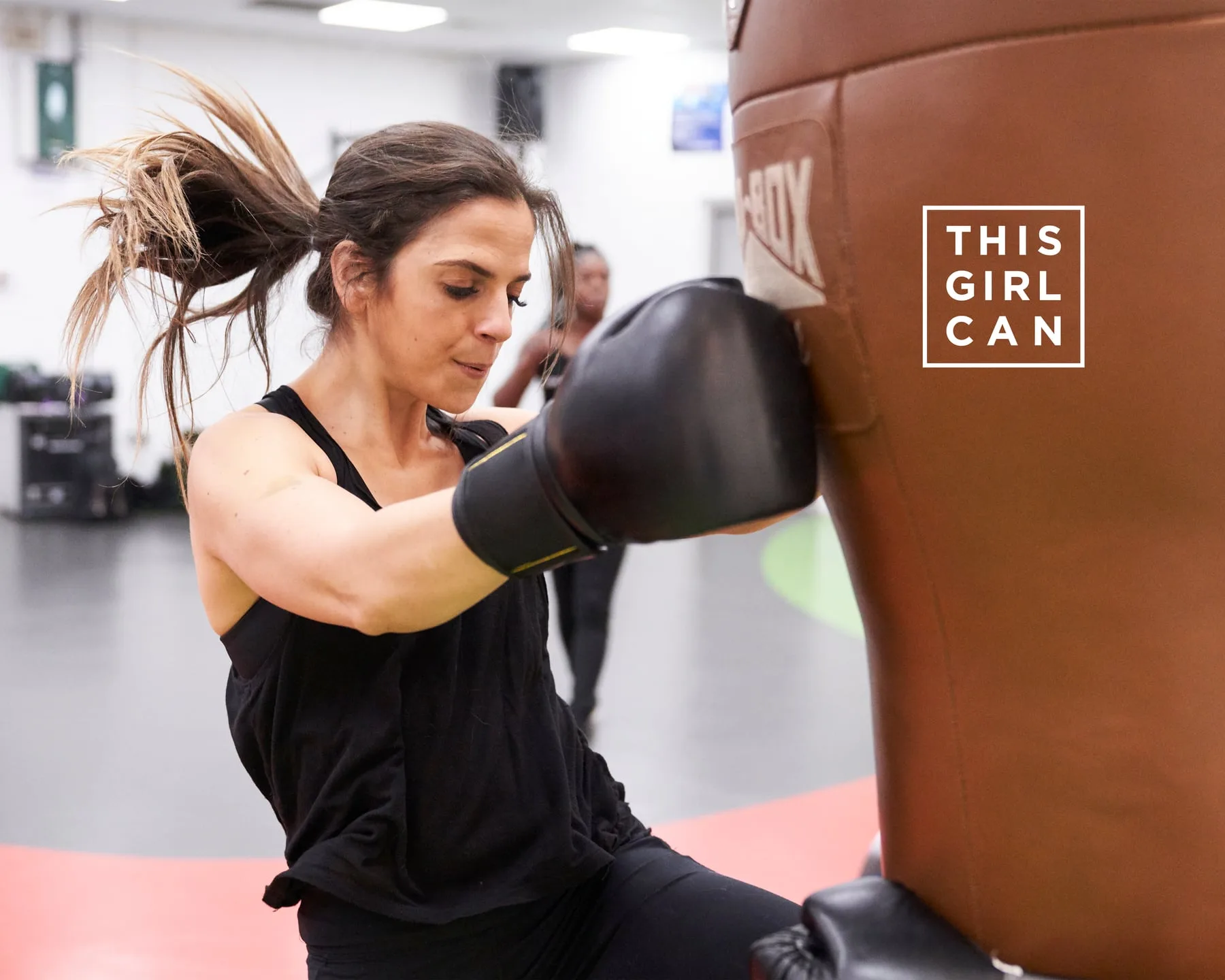 A woman boxing a heavy bag in the gym, This Girl Can